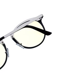 Svarta och silverfärgade solglasögon med runda linser och gult tonat glas. Funktioner inkluderar metallaccenter, klara näskuddar och eleganta svarta skalmar.