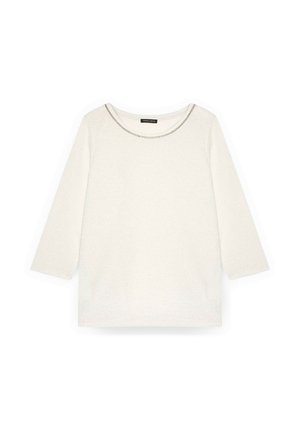 Bluză albă cu mâneci lungi, având un decolteu rotund, cu cusături accentuate argintii. Este fabricată dintr-un material moale, cu textură, având o croială lejeră.