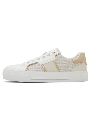 Baskets basses avec semelle blanche, côtés en tissu tweed beige, lacets blancs et détails métalliques dorés sur le talon et les œillets.