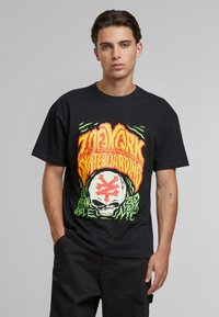 Sort bomulds t-shirt med et farverigt grafisk design, der har teksten "Zoo York Skateboarding", et kranium og livlige farver i en fed stil.