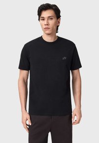 Μαύρο βαμβακερό μπλουζάκι με στρογγυλή λαιμόκοψη και κοντά μανίκια. Διαθέτει διακριτική κεντημένη λογότυπο στο αριστερό στήθος. Ομαλή υφή.