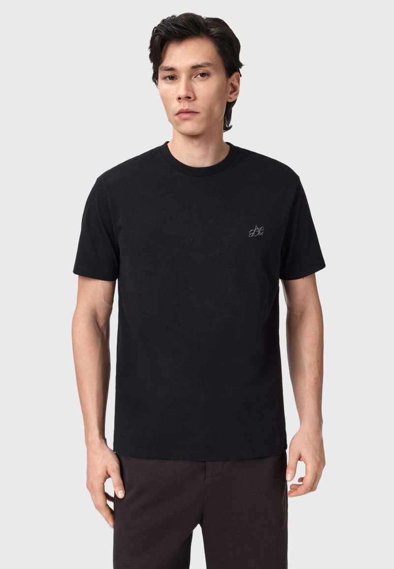 Μαύρο βαμβακερό μπλουζάκι με στρογγυλή λαιμόκοψη και κοντά μανίκια. Διαθέτει διακριτική κεντημένη λογότυπο στο αριστερό στήθος. Ομαλή υφή.