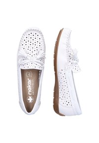Mocassins en cuir perforé blanc avec un nœud décoratif, dotés d'une semelle en caoutchouc marron et d'une semelle intérieure texturée. Design décontracté à enfiler.