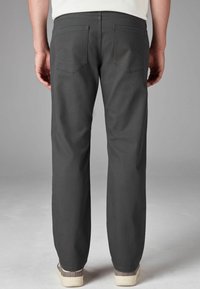 Pantaloni gri închis cu croială dreaptă, având două buzunare pe spate. Materialul pare robust, cu o textură netedă, asortat cu pantofi deschiși.