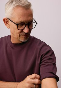 Kortærmet, dyb burgundy t-shirt lavet af blødt, tekstureret stof med en afslappet halsudskæring og opsmøgede ærmer.