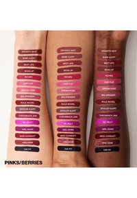 Läppstiftsnyanser i olika rosa och bärfärger på två armar. Inkluderar namnen på nyanserna tryckta ovanför varje swatch.