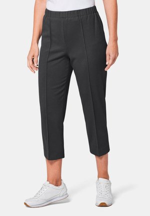 Zwarte cropped broeken van een gestructureerde stof, met een gestikt ontwerp en een elastische tailleband, gedragen met witte sportschoenen.