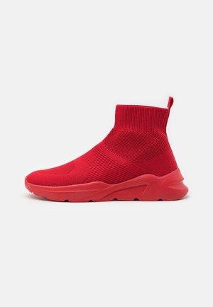 Baskets montantes rouge vif style chaussette en tissu tricoté texturé avec semelle épaisse en caoutchouc, montrées de profil sur fond uni.