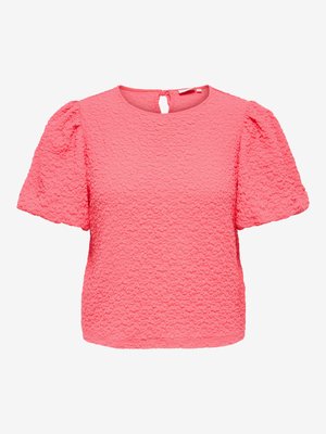Blouse rose texturée à manches courtes avec manches bouffantes et fermeture à bouton en forme de trou à la nuque.