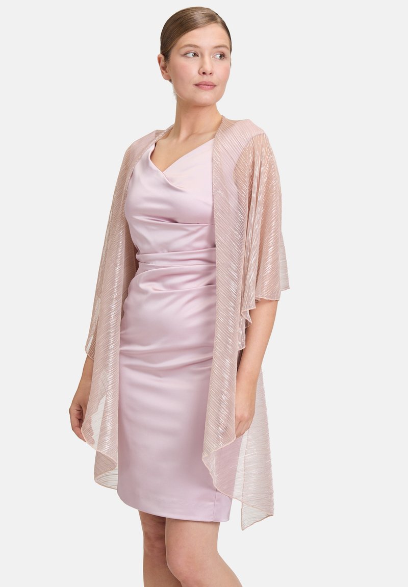 Bleekroze doorschijnende kimono met een geplooid ontwerp, gedrapeerde stijl en fluttermouwen, gedragen over een gladde roze jurk met een V-hals.