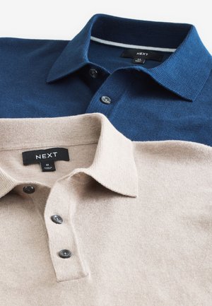 Zwei Poloshirts: eines navyblau, das andere beige. Beide haben einen Kragen, eine Knopfleiste und einen strukturierten Stoff. Etiketten sind am Ausschnitt sichtbar.