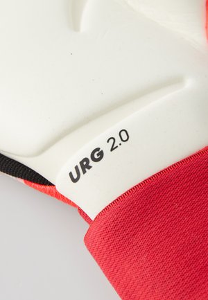Gant de gardien de but avec une manchette en tissu rouge, paume en latex blanc, prise texturée et logo "URG 2.0" ; présente une forme ergonomique pour le confort.
