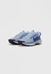 Lichtblauwe hardloopschoenen met een bovenwerk van mesh, een gestructureerd oppervlak, een marineblauwe teencap en een zwarte zool. Heeft een opvallende blauwe swoosh en veters.