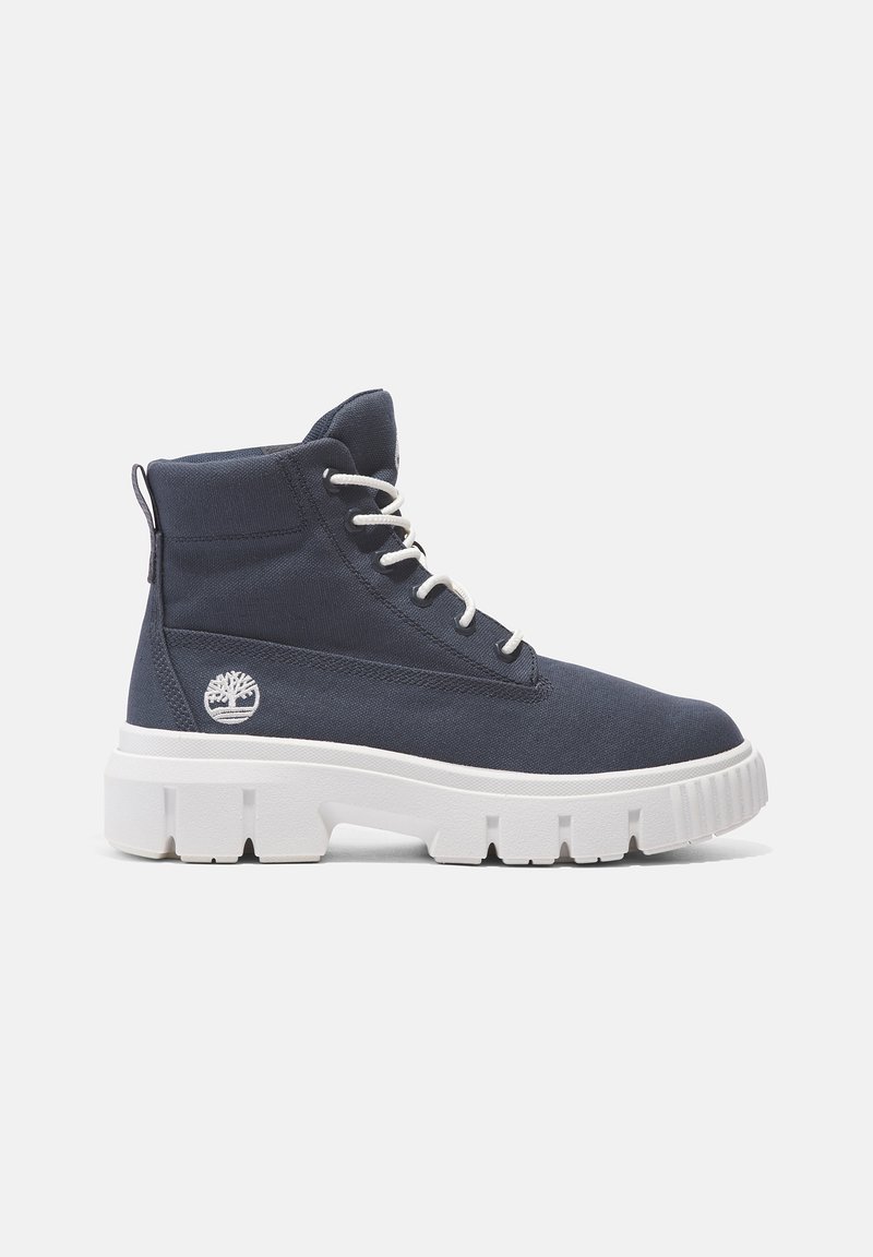 Navy Canvas-Ankleboots mit weißer Sohle, ausgestattet mit einer Schnürung und einem kleinen Logoakzent an der Seite. Texturiertes Obermaterial und robuste Konstruktion.