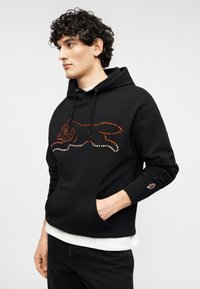 Μαύρο φούτερ με κουκούλα και τσέπη καγκάρου, με πολύχρωμο σχέδιο από στρας που απεικονίζει μια γάτα. Μείγμα βαμβακιού, μαλακή υφή, μακριά μανίκια.