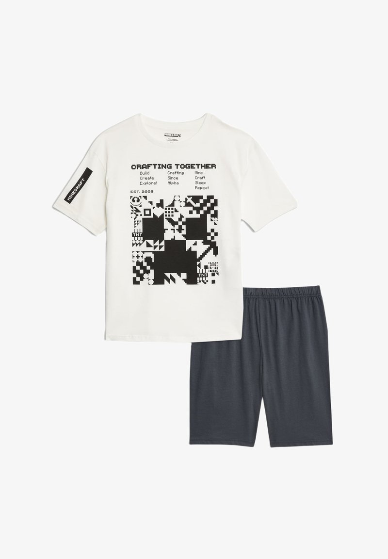 White t-shirt with black graphic design and text, paired with dark gray shorts. Cotton material, short sleeves, elastic waistband.