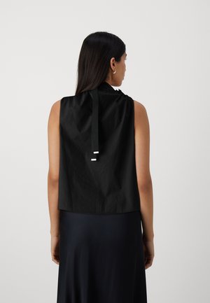Top nero senza maniche con una texture liscia, dotato di una chiusura posteriore a fiocco e un orlo arrotondato per una vestibilità comoda.