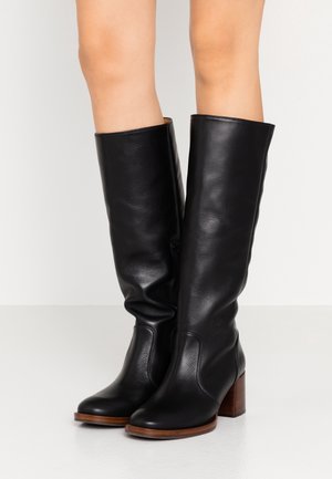 Czarne, skórzane kozaki do kolan z zaokrąglonym noskiem, obcasem typu blok oraz gładką fakturą. Posiadają zamek błyskawiczny po bokach. Naturalny drewniany akcent na obcasie.