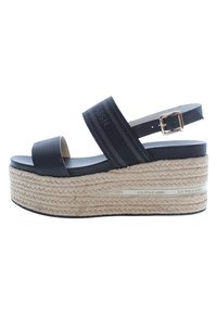Sandalias de plataforma negras con suela de yute trenzada, que cuentan con una tira ancha y un hebilla ajustable en el tobillo. Decoradas con el texto de la marca.
