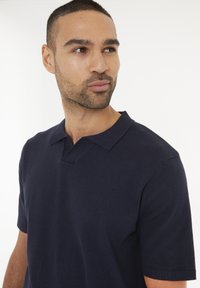 Námořnická polokošile s krátkým rukávem vyrobená z měkké pleteniny, s žebrovaným límcem a designem do V.