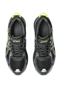 Chaussures de sport noires avec un dessus en maille et synthétique, accents vert lime, tissu texturé et semelle rembourrée au design élégant.