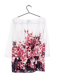 Blusa bianca con maniche 3/4, caratterizzata da una stampa floreale in rosa e blu navy, vita arricciata e texture del tessuto liscia.