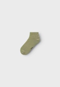 Calcetín de tobillo verde claro hecho de tela suave, con un puño de canalé y una pequeña etiqueta de tamaño negra en el lateral.