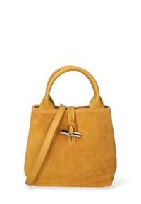 Borsa in suede gialla con due manici superiori arrotondati, tracolla staccabile e chiusura a morsetto in tonalità argento. Texture morbida con forma strutturata.