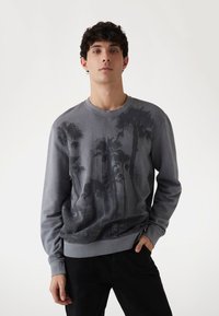 Felpa grigia con motivo di palme, colletto a girocollo e polsini a coste. Il tessuto è liscio con una leggera texture. Design semplice.