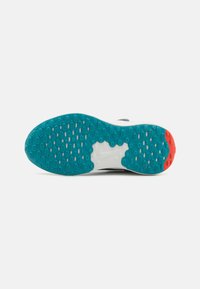 Semelle de chaussure de course avec une surface en caoutchouc turquoise texturé, une semelle intermédiaire blanche et un accent rouge, conçue pour l'adhérence et la durabilité.