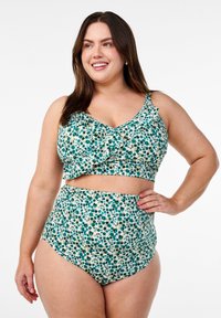Cvetni bikini set, ki vključuje krojeni zgornji del z naborki in hlačke z visokim pasom. Tkanina je kremne barve z zelenimi in modrimi vzorci.