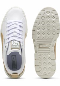 Vit sneaker med en slät läderöverdel, beige mockadetaljer, vita snören, vadderad krage, logopatch och mönstrad gummisula.