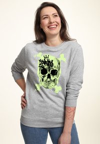 Felpa grigia con un design grafico di teschio in nero e verde neon, con ossa incrociate e accenti di spruzzi. Materiale in cotone, vestibilità relax.