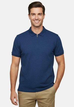 Donkerblauw poloshirt met een ritskraag, korte mouwen en textuurstof. Gecombineerd met khaki broeken met een aansluitend ontwerp.