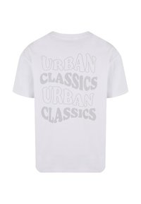 Balta kokvilnas T-kreklu ar tekstu "URBAN CLASSICS" pelēkā krāsā, kas izcelta viļņotā fontā uz muguras. Īsas piedurknes un brīvs piegriezums.