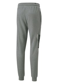 Pantalons de sport gris en tissu doux, dotés d'une taille avec cordon de serrage, de poches latérales et d'un motif géométrique sur la jambe gauche.