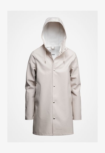 Lichtbeige regenjas met een capuchon, gemaakt van glad waterdicht materiaal. Bevat drukknoopsluitingen, trekkoorden en zijzakken. Eenvoudig ontwerp.