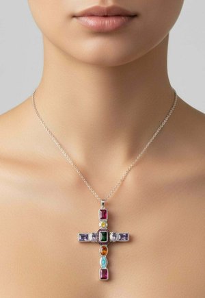 Nyaklánc ezüst lánccal, amelyen egy kereszt alakú medál díszeleg, több színű, téglalap és ovális alakú drágakövekkel, egy nő nyakán.