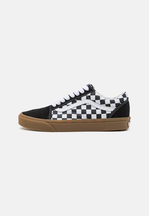 Black and white checkerboard canvas sneakers with a gum rubber sole and white laces, featuring a side logo and suede accents.