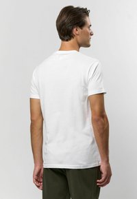 Bílá bavlněná tričko s kulatým výstřihem, krátkými rukávy a hladkou texturou, pohled ze zad. Žádné viditelné loga ani vzory.