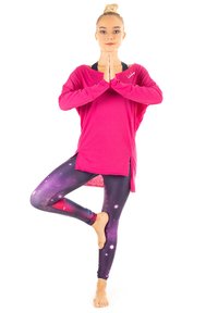 Långärmad, löst sittande rosa topp som matchas med kroppsnära leggings i galaxmönster i mörklila och rosa, som visar en kosmisk design.