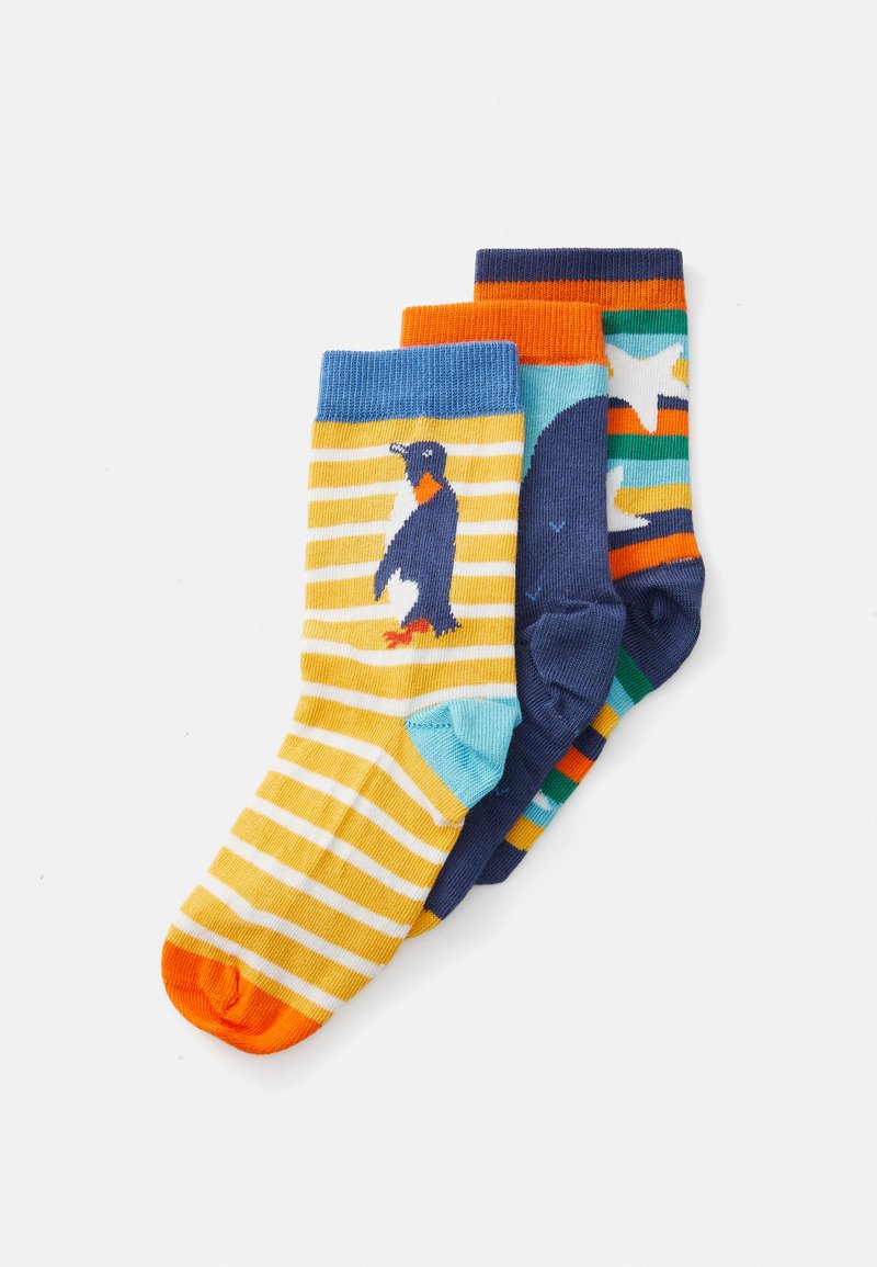 Drei Paare Kindersocken: eine gelb gestreifte mit einem Pinguin-Motiv, eine marineblaue mit einem Wal und eine mehrfarbige mit Sternen und Streifen.