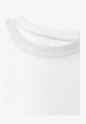 Bijela majica s okruglim izrezom od mekanog pamuka, s rebrastim ovratnikom i otisnutom oznakom branda unutar vrata.