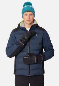 Doudoune marine avec des accents noirs et une capuche grise, associée à des mitaines noires avec des rayures blanches. Bonnet tricoté en turquoise avec un pompon.