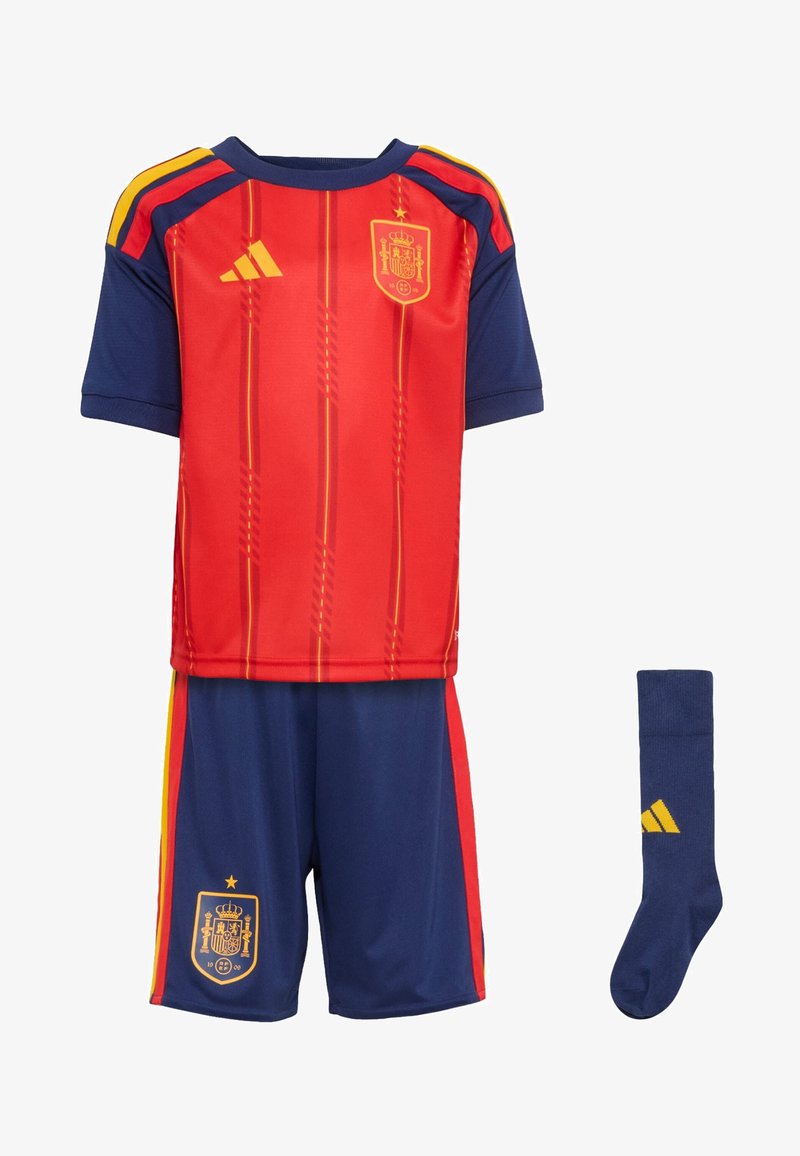 Červený a tmavomodrý detský futbalový dres s krátkymi rukávmi, horizontálnymi pruhmi, španielskym erbom, zodpovedajúcimi šortkami a tmavomodrými ponožkami.