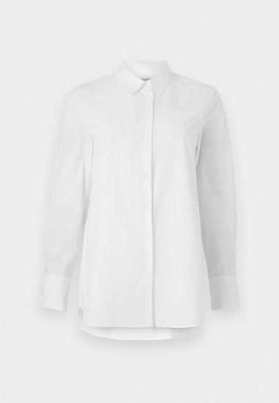 Camicia bianca a maniche lunghe in cotone. Presenta un colletto classico, chiusura con bottoni e una tasca sul petto con un sottile design ricamato.