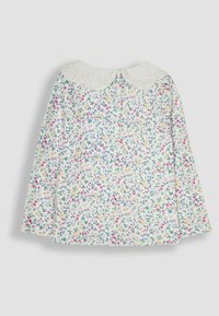 Weißes Langarmoberteil mit floralem Druck in Rosa-, Lila- und Gelbtönen sowie einem wellenförmigen Spitzenkragen. Rückwärtiger Knopfverschluss.