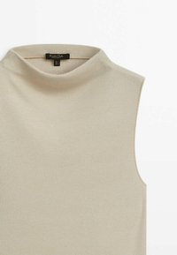 Beżowy bezrękawnik z wysokim, zaokrąglonym dekoltem. Wykonany z prążkowanego materiału, o gładkiej fakturze i minimalistycznym designie.