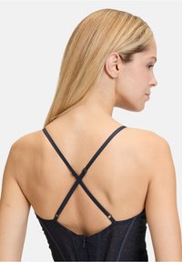 Marineblauwe jurk met gekruiste dunne bandjes, textuurstof met een subtiele glans en een ritssluiting aan de achterkant, met een figuuraccentuerend ontwerp.