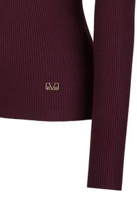 Rippstrick-Pullover in Burgunderrot mit passgenauer Silhouette. Verfügt über ein goldenes Logo-Detail am Saum für Markenidentität und Texturkontrast.